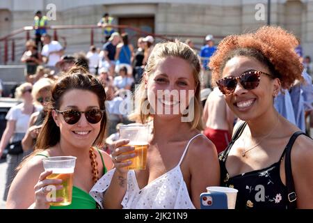 Three happy woman in a crowd at Bristol Harbour festival, UK Stock Photo