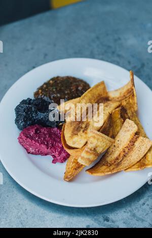 a plate of plantain chips and dips at outdoor restaurant Stock Photo