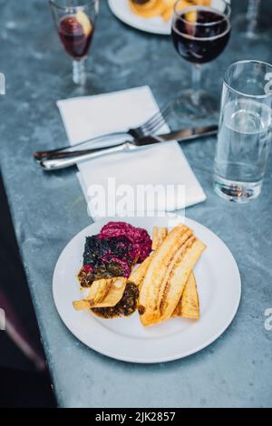 Plantain chips and dips at outdoor restaurant on metal patio table with wine glasses Stock Photo