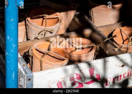 Background of packed brown ceramic clay pots. Concept container new tied with string. Decorative earthenware environment friendly flowerpots. Fragile Stock Photo