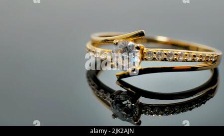 Gold jewelry ring with diamond on reflected black table Stock Photo