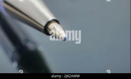 Close-up of ballpoint. Focus on tip. Toned in blue Stock Photo