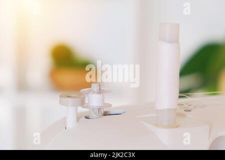 Winding threads on a bobbin on a sewing machine. Stock Photo