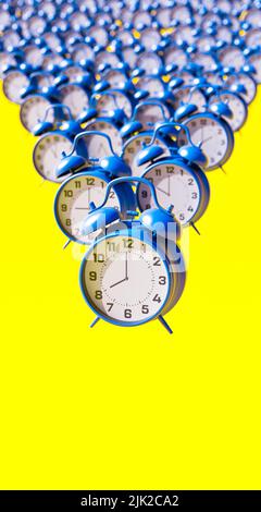 Blue alarm clocks on vibrant yellow background vertical composition 3d render 3d illustration Stock Photo