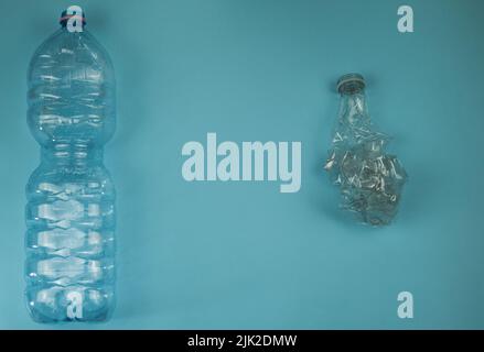 Used plastic bottles crushed and crumpled against on the blue background Recycling concept Stock Photo