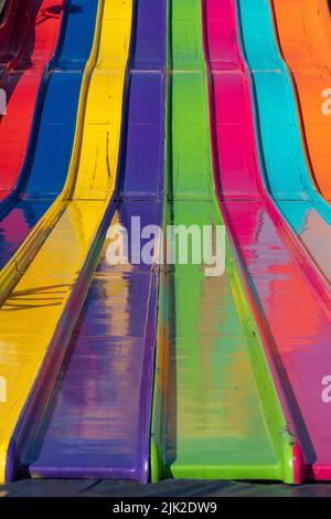 Close up abstract view of a large giant slide at the fairgrounds in rainbow colors Stock Photo