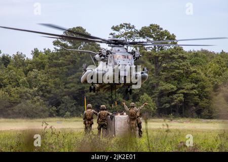 U.S. Marines assigned to Combat Logistics Battalion 24, 2nd Marine Logistics Group, and a CH-53E Super Stallion assigned to Marine Heavy Helicopter Squadron 366, 2nd Marine Aircraft Wing, conduct an external lift during Hide and Seek Exercise on Marine Corps Base Camp Lejeune, North Carolina, July 27, 2022. Hide and Seek Exercise is a field exercise hosted by 10th Marines, 2nd Marine Division that trains participants on signature management, communication, electronic warfare, cyberspace operations and intelligence collection, processing and dissemination in order to enable future operations in Stock Photo
