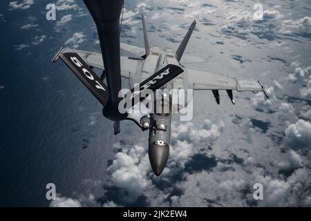 PACIFIC OCEAN (July 26, 2022) U.S Air Force KC-135 Stratotanker refuels a U.S. Navy F-18 Super Hornet through its flying boom extending from the rear of the aircraft during Rim of the Pacific (RIMPAC) 2022. Twenty-six nations, 38 ships, three submarines, more than 170 aircraft and 25,000 personnel are participating in RIMPAC from June 29 to Aug. 4 in and around the Hawaiian Islands and Southern California. The world's largest international maritime exercise, RIMPAC provides a unique training opportunity while fostering and sustaining cooperative relationships among participants critical to ens Stock Photo