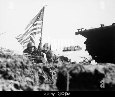 Two U.S. officers plant the first American flag on Guam just after U.S. Marines and Army assault troops landed on the Central Pacific island on July 20, 1944. Stock Photo