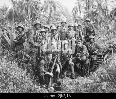 A group of U.S. Marine Raiders gathered in front of a Japanese dugout on Cape Totkina on Bougainville, Solomon Islands, which thry helped to take., Stock Photo
