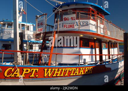 A charter fishing boat is docked on a pier in Captree State Park, Long Island Stock Photo