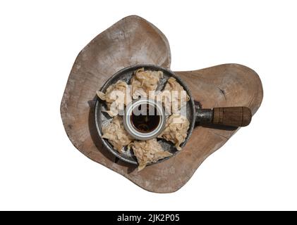 Delicious shrimp dumplings served with Soy sauce on wooden cutting board isolated on white background with clipping path. Selective focus. Stock Photo