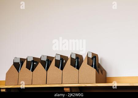 Cardboard boxes with bottles of wine standing on the shelves in the wine store Stock Photo