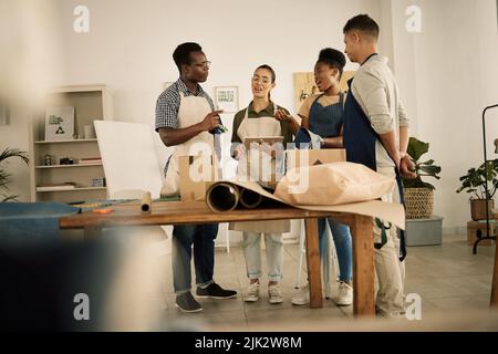 Group of designers doing design teamwork while talking and working on a creative project. A team of diverse fashion studio workers brainstorming Stock Photo