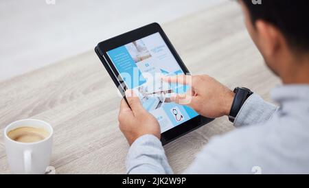 Time to start redecorating. a businessman drinking coffee while using his digital tablet. Stock Photo
