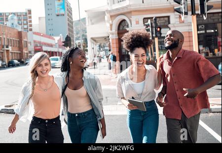 Happy, young and free trendy friends having fun on a day in the city, laughing while walking and talking together. Diverse group exploring downtown Stock Photo