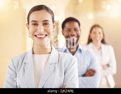 Make the most of your strengths and abilities. Portrait of a young businesswoman standing in an office with her colleagues in the background. Stock Photo