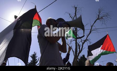 Jerusalem, Israel. 29th July, 2022. JERUSALEM, ISRAEL - JULY 29: Israeli left-wing activists and Palestinians hold Palestinian flags and shout slogans during a demonstration against Israeli occupation and settlement activity in the Sheikh Jarrah neighborhood on July 29, 2022 in Jerusalem, Israel. The Palestinian neighborhood of Sheikh Jarrah is currently the center of a number of property disputes between Palestinians and right-wing Jewish Israelis. Some houses were occupied by Israeli settlers following a court ruling.  Credit: Eddie Gerald/Alamy Live News Credit: Eddie Gerald/Alamy Live News Stock Photo