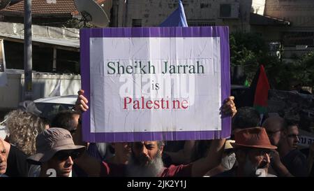 Jerusalem, Israel. 29th July, 2022. JERUSALEM, ISRAEL - JULY 29: An Israeli left-wing activist holds a sign which reads 'Sheikh Jarrah is Palestine' during a demonstration against Israeli occupation and settlement activity in the Sheikh Jarrah neighborhood on July 29, 2022 in Jerusalem, Israel. The Palestinian neighborhood of Sheikh Jarrah is currently the center of a number of property disputes between Palestinians and right-wing Jewish Israelis. Some houses were occupied by Israeli settlers following a court ruling. Credit: Eddie Gerald/Alamy Live News Stock Photo