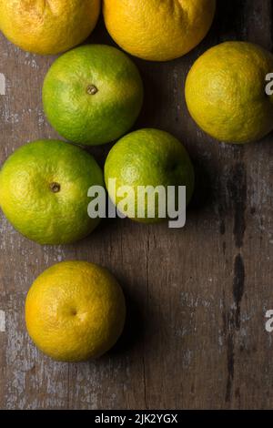 sweet orange fruits scattered on rustic wooden table top, taken directly from above with space for text Stock Photo
