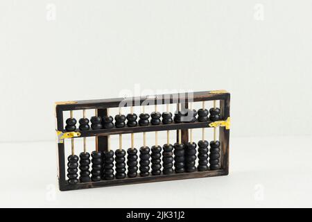Vintage Abacus, Swipoa or Sempoa made from Wooden. Traditional Chinese Calculator Isolated on Cream Background Stock Photo