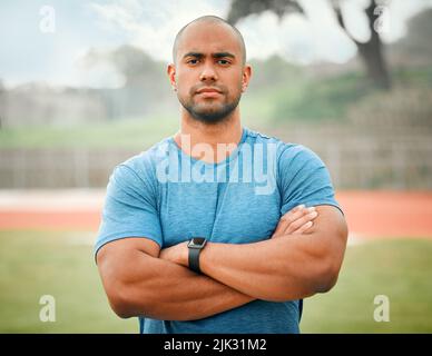 Confident in my sporting abilities. Cropped portrait of a handsome young male athlete standing outside with his arms folded. Stock Photo