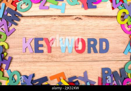 colorful wooden letter of the alphabet and the word Key word isolated on wood background Stock Photo
