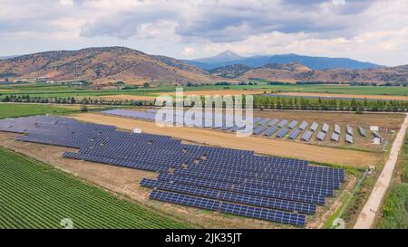 beautiful aerial view of solar panel cell on the field and Mt Osa in background, Greece. High quality photo Stock Photo