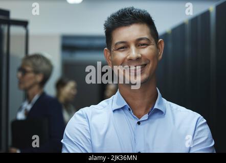 Another version of a beautiful mind. Portrait of a happy man working in a server room. Stock Photo