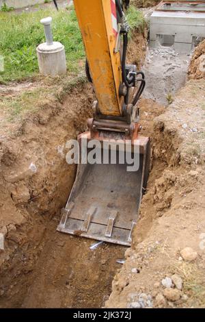 Excavator shovel digs into loamy soil Stock Photo