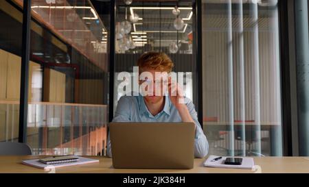 Young worried businessman checks financial crisis report on laptop computer.  Stock Photo