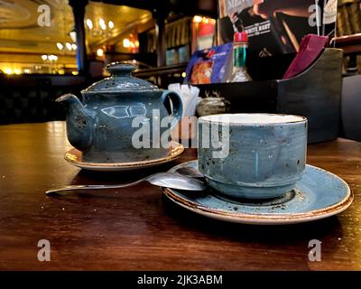 hunting pub decorated in the old English style. antique furniture made of red oak and beech, an old blue cup and teapot in a gap, on the table Stock Photo
