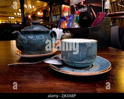 hunting pub decorated in the old English style. antique furniture made of red oak and beech, an old blue cup and teapot in a gap, on the table Stock Photo