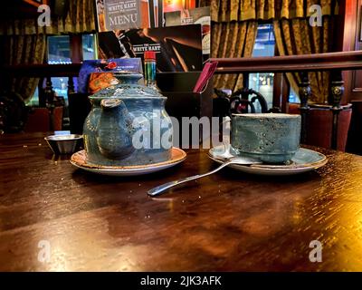hunting pub decorated in the old English style. antique furniture made of red oak and beech, an old blue cup and teapot in a gap, on the table Stock Photo