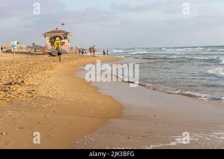 Haifa, Israel - 20 July 2022, Dado beach. People run along the sea. lifeguard tower Stock Photo