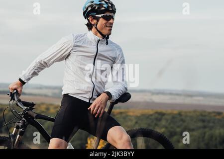 Professional Male Cyclist with His Bike Outdoors, Adult Man Wearing Helmet and Protection Sport Glasses Looking Away, Copy Space Stock Photo