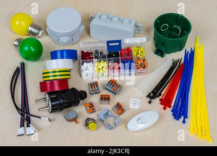 Multi-colored electrical components and parts on a plywood background. Stock Photo