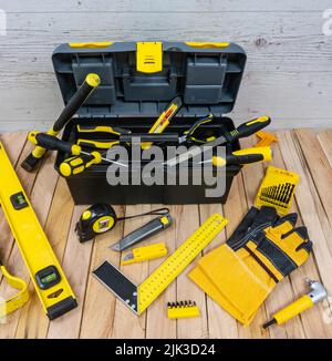 Construction instruments and a tool box on a wooden planks background. All tools and a box with yellow elements. Stock Photo