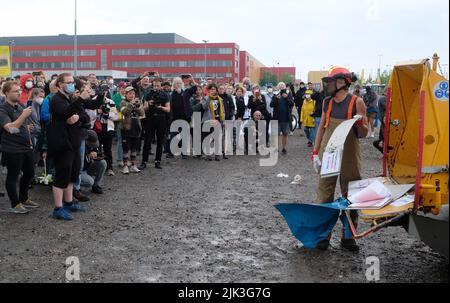 Schkeuditz, Germany. 30th July, 2022. An activist symbolically shreds the application documents for the expansion of the airport during a rally at Leipzig-Halle Airport. About 250 people protest against the planned expansion of the cargo hub. Credit: Sebastian Willnow/dpa/Alamy Live News Stock Photo