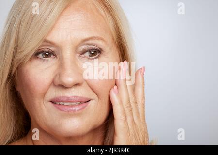 Portrait of beautiful blond senior woman posing and looking away. Beauty photography Stock Photo