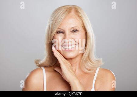Beautiful senior lady touching her soft wrinkled skin. Beauty photography Stock Photo
