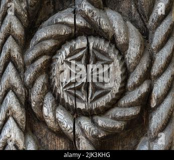 Old hand carved bas-relief ornament with a flower design. Abstract wood carving art and craft. Stock Photo