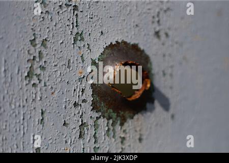 Fence near the house with bullet holes and charapnels after gunshots and fighting during the invasion of Russian troops into Ukraine Stock Photo