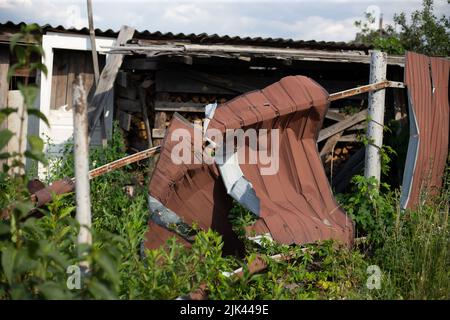 Fence near the house with bullet holes and charapnels after gunshots and fighting during the invasion of Russian troops into Ukraine Stock Photo