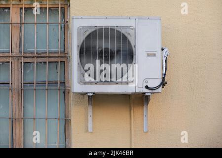 old outdoor air conditioner unit hanging outside the building Stock Photo