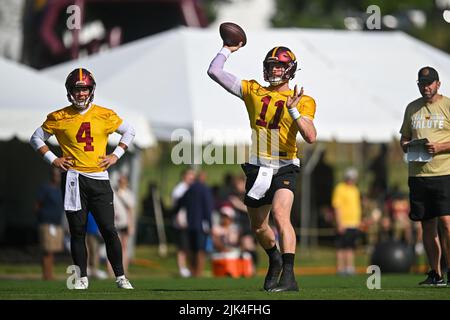 Ashburn, VA, USA. 30th July, 2022. Washington Commanders quarterback Carson Wentz (11) throws a pass while Washington Commanders quarterback Taylor Heinicke (4) looks on during the Washington Commanders Training Camp practice at the INOVA Sports Performance Center in Ashburn, Va. Reggie Hildred/CSM/Alamy Live News Stock Photo