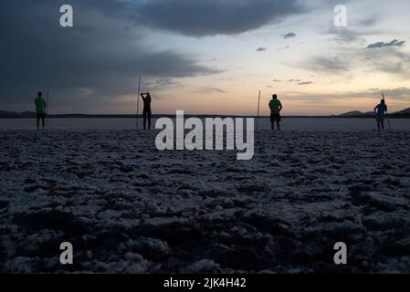 Malaga, Spain. 30th July, 2022. Volunteers are seen holding sticks at dawn as they wait during the tagging, evaluating and identifying of flamingo chicks to control their conservation at Fuente de Piedra Lake in Malaga. This lagoon is a nature reserve and breeding ground for flamingos where visitors can observe many species in their natural habitat. This year around 600 flamingo chicks were tagged with the assistance of 400 volunteers. (Photo by Jesus Merida/SOPA Images/Sipa USA) Credit: Sipa USA/Alamy Live News Stock Photo