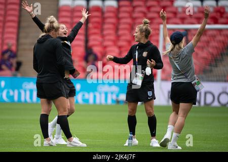 30 July 2022, Great Britain, London: Soccer: national team, women, European Championship 2022, before the final, pitch inspection England, Wembley Stadium: England's Millie Bright (l-r), Ellen White, Rachel Daly and Beth Mead cheer after Daly threw a bottle straight onto the ground with a spin. Photo: Sebastian Gollnow/dpa - IMPORTANT NOTE: In accordance with the requirements of the DFL Deutsche Fußball Liga and the DFB Deutscher Fußball-Bund, it is prohibited to use or have used photographs taken in the stadium and/or of the match in the form of sequence pictures and/or video-like photo serie Stock Photo