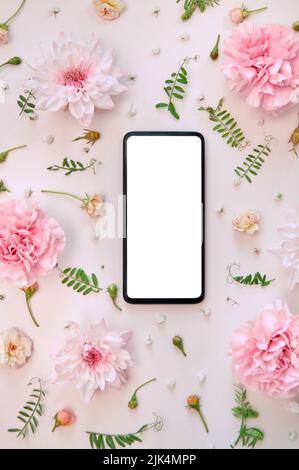 Phone mock up screen on pink flowers white floral background. Flat lay, vertical Stock Photo