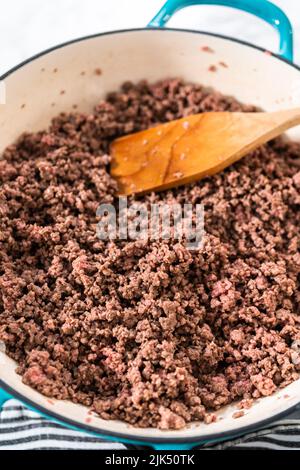 Browning ground beef in cast iron skillet to make homemade hamburger helper. Stock Photo